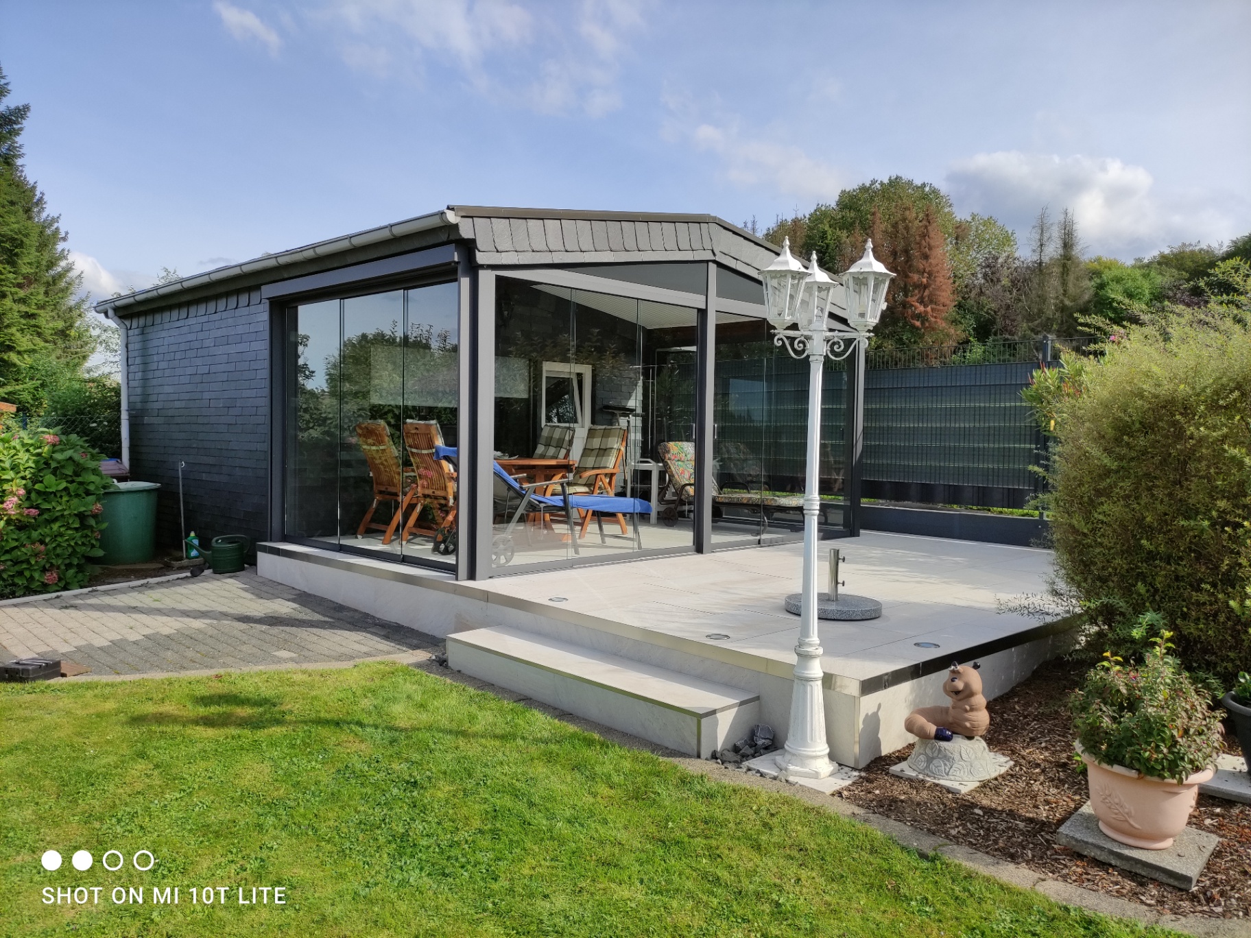 Terrassenüberdachung mit gläsernen Schiebeelementen und Anthrazit-Rahmen