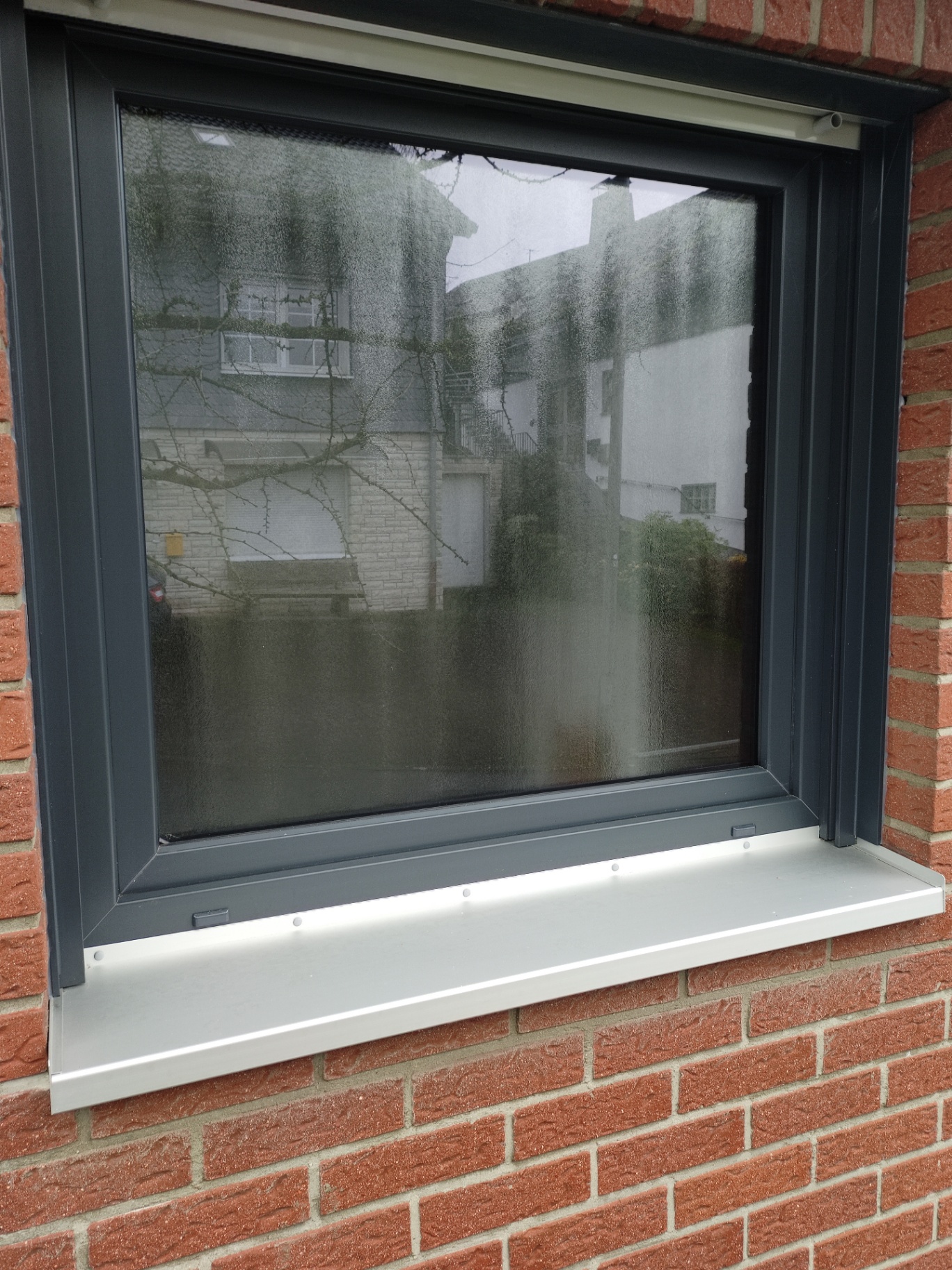 Anthrazitfarbenes Fenster in Klinkerfassade