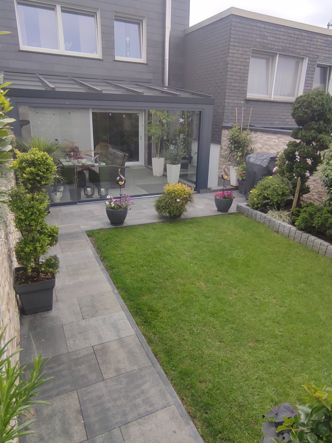 Garten mit Terrasse, Glas-Überdachung und Pflasterweg
